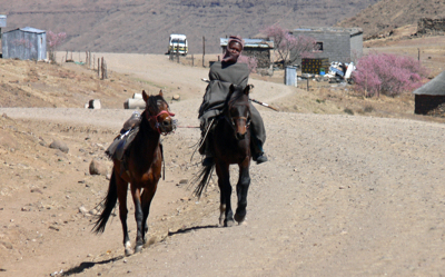 A Lesotho man riding along the road.