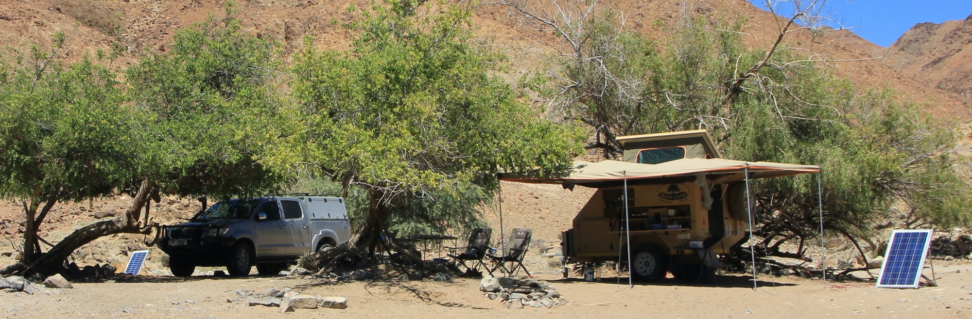 Hilux and Bush Lapa van with solar panels set up.
