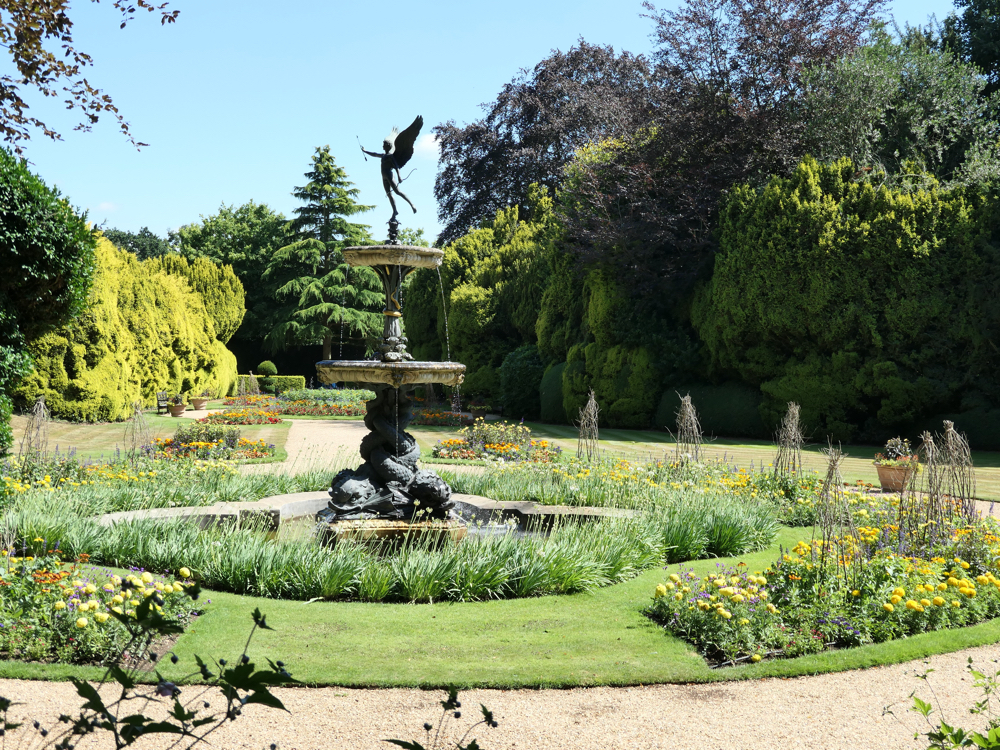 Flowers beds and walkways with a central fountain.