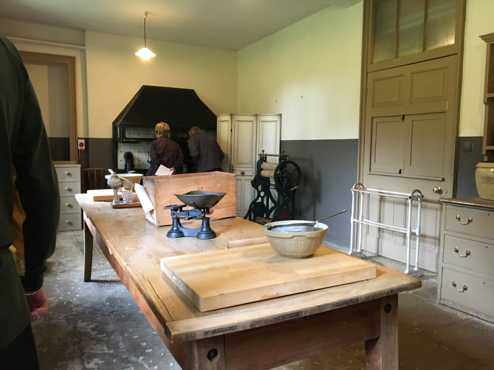 A kitchen table with scales and a pastry bowl and board.