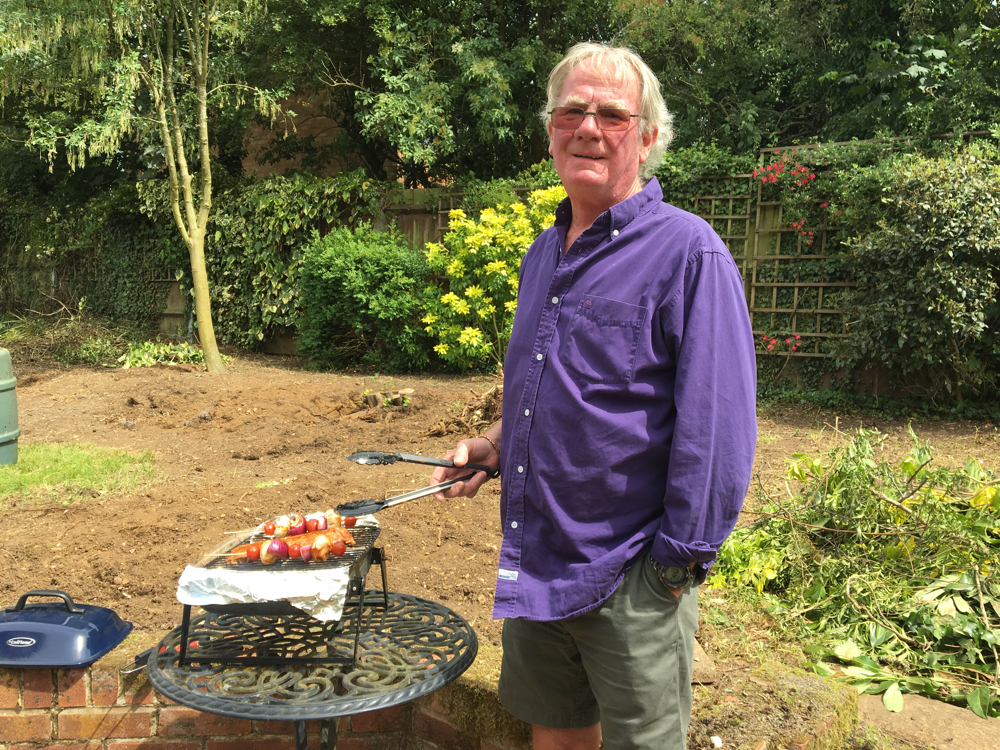 Kevin cooking with our small BBQ on a table.