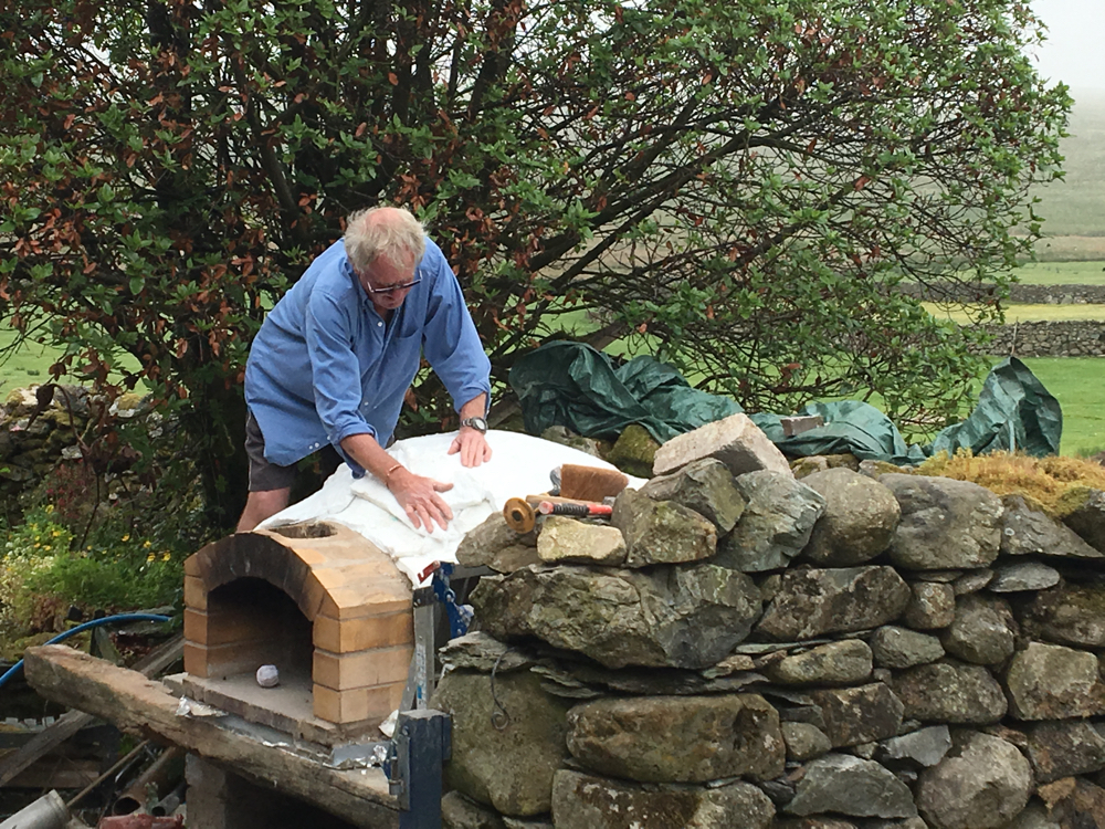 Kevin putting layers of insulating mat on the roof of the pizza ocen.
