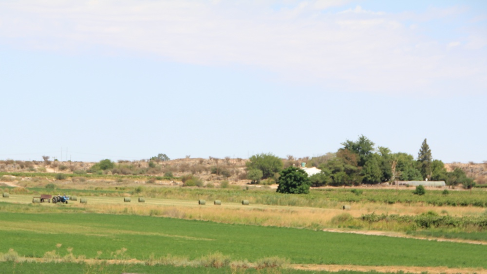 Grass fields being bales.