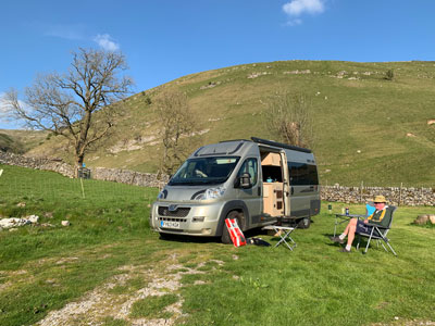 Kevin sitting outside the van at the campsite